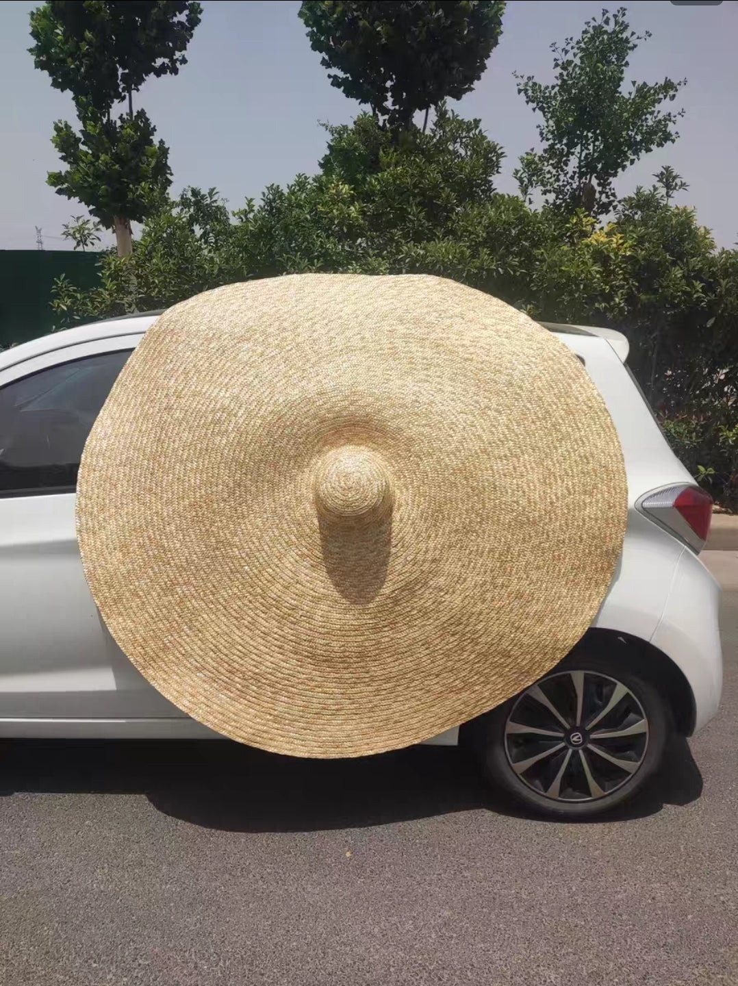 Flat lay of extra large 180cm straw beach hat in natural tan colo