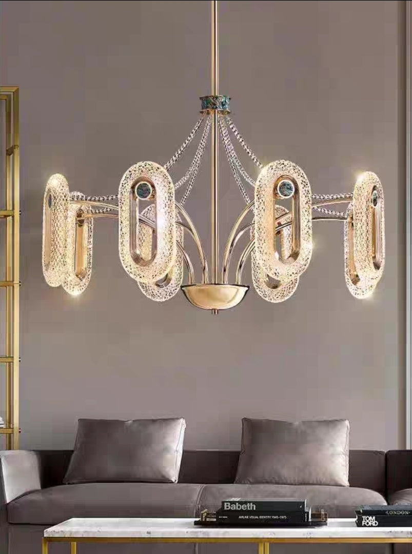 Close-up of luxury gold chandelier with abalone inlay and crystal strands, featuring oval LED lights