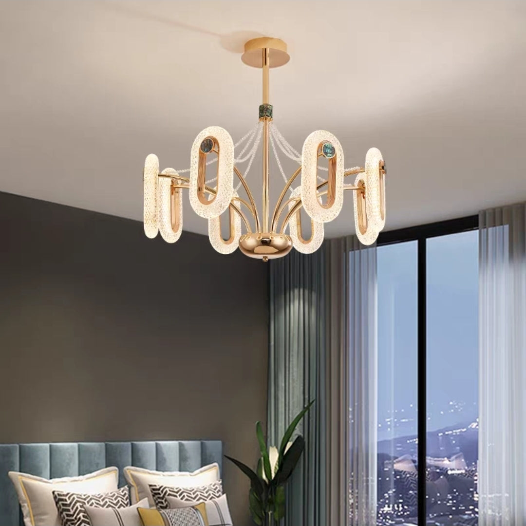 Close-up of gold LED chandelier with elegant ring lights and abalone shell decor.