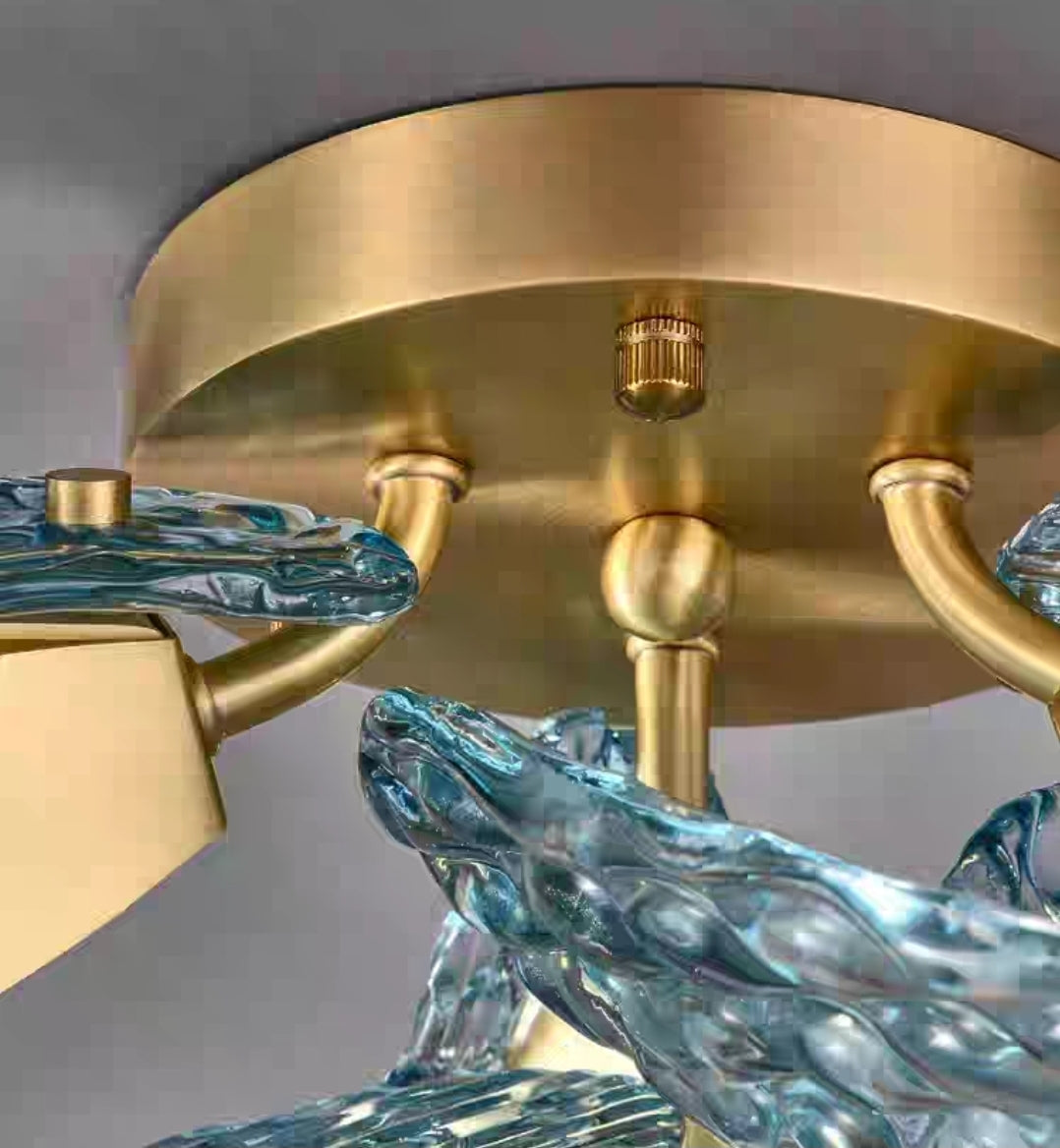 Close-up of a chandelier with gold fixture and blue glass elements.