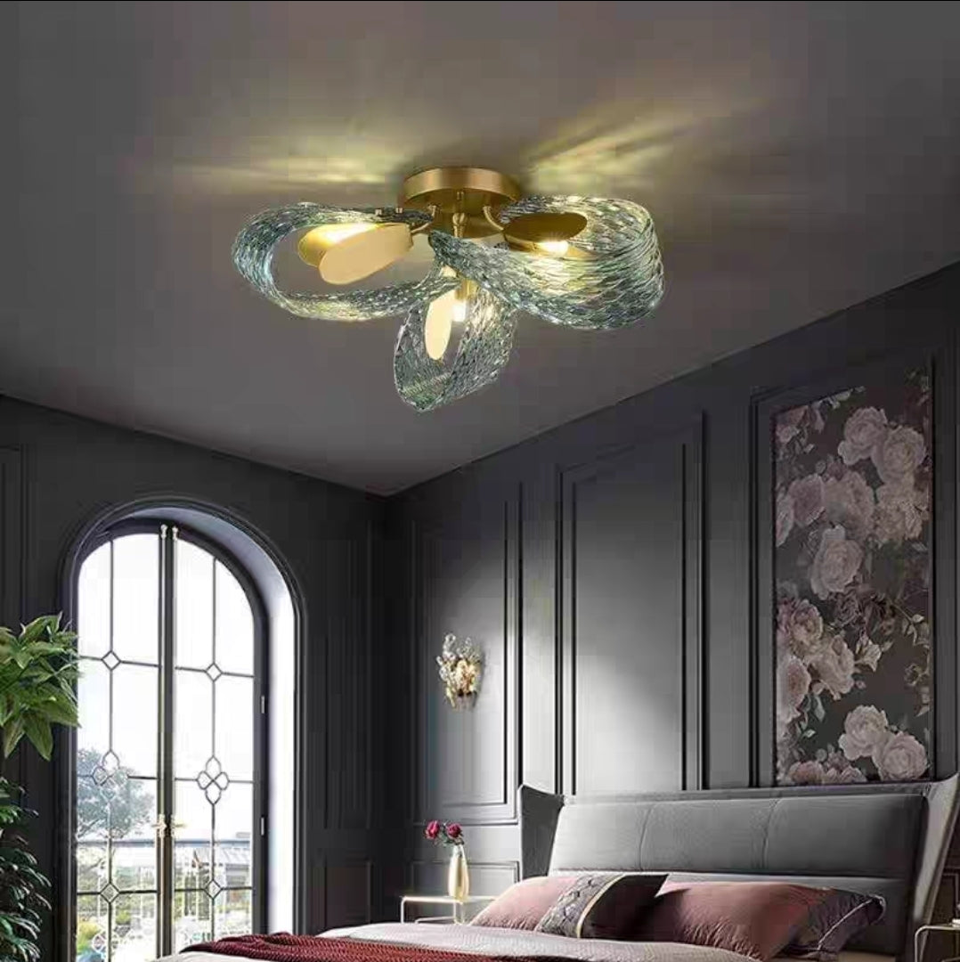 Modern ceiling light fixture in a stylish bedroom with dark walls and floral decor.