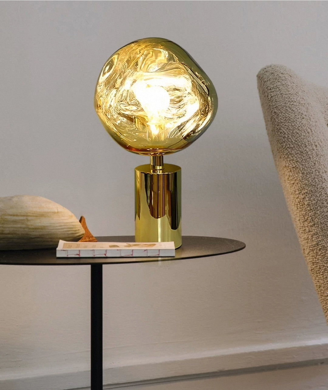 Gold base bedside lamp with molten effect globe on decorative console table.