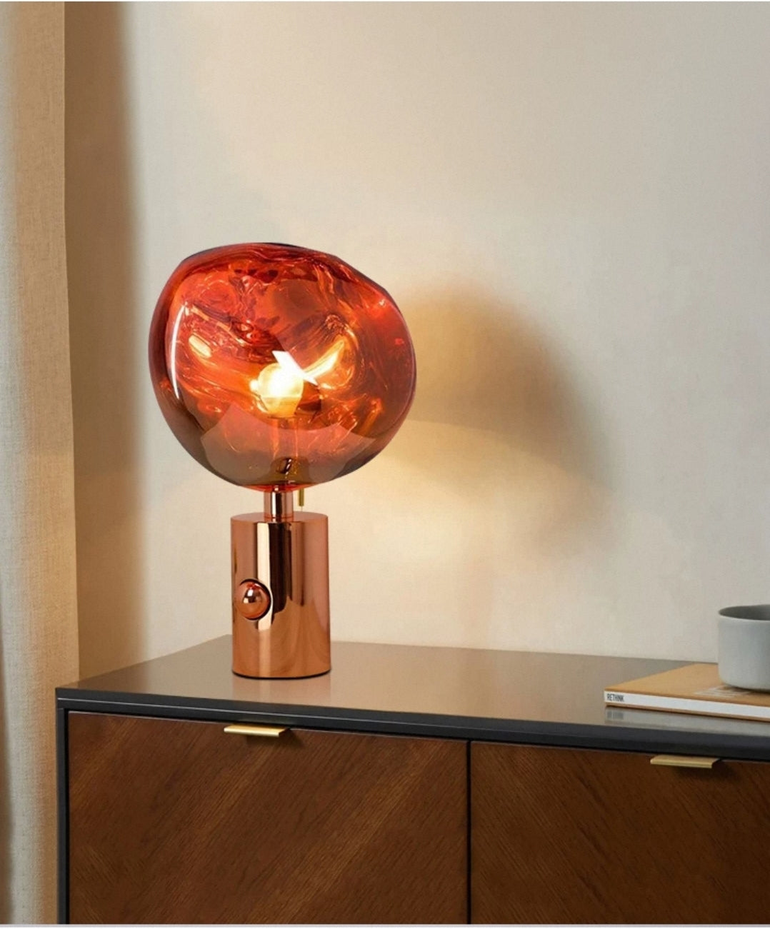 Artistic table lamp with hand-blown molten glass globe on home office shelf.