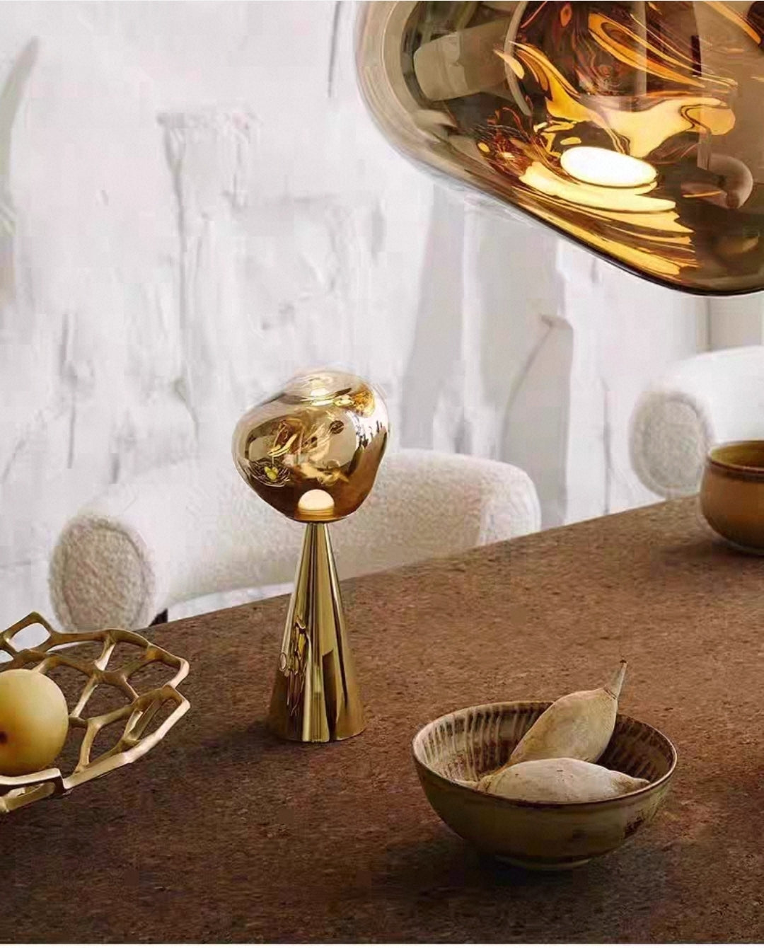 Gold LED lamp on a table with a marble wall in the background