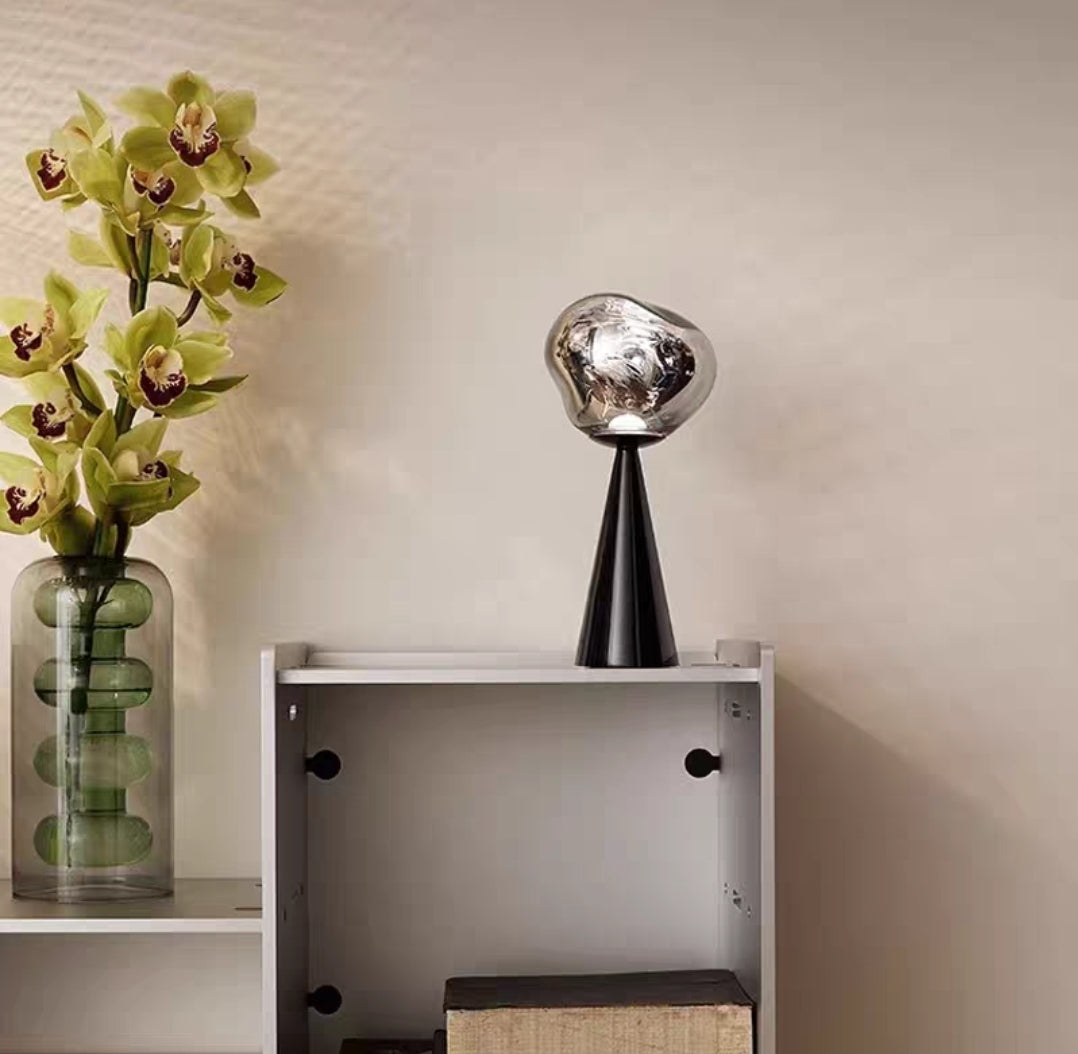 Compact rechargeable LED lamp displayed on a wooden nightstand.