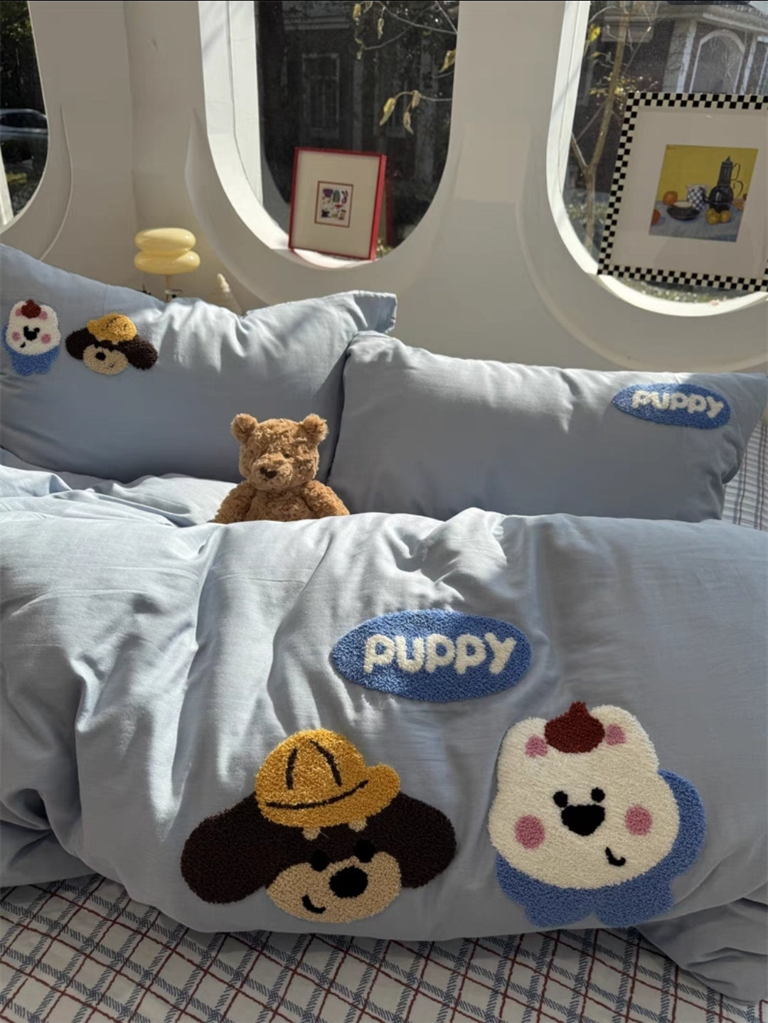 Gray  cartoon embroidered bedding set with rabbit designs and a teddy bear on a bed.