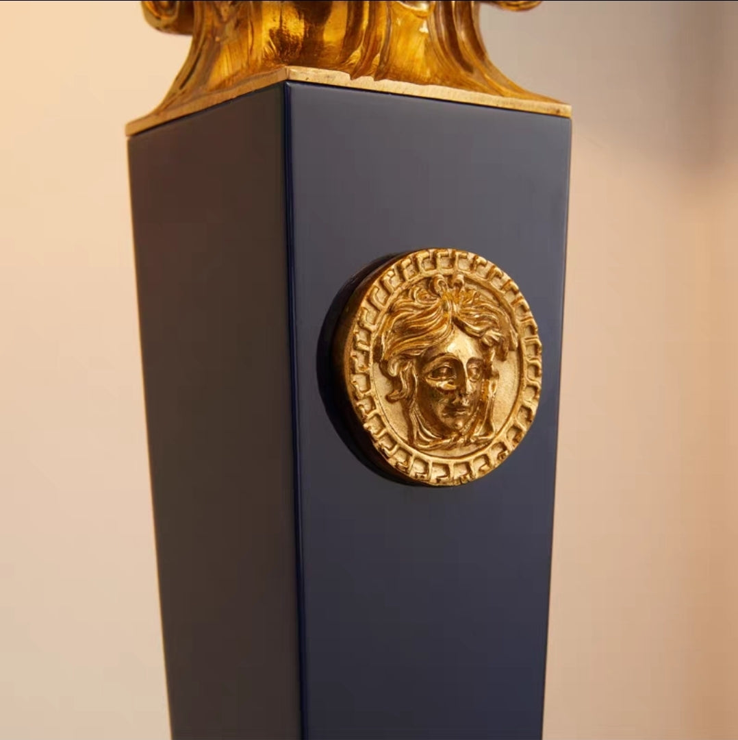 French vintage brass table lamp with gold emblem on a blue base against a beige background