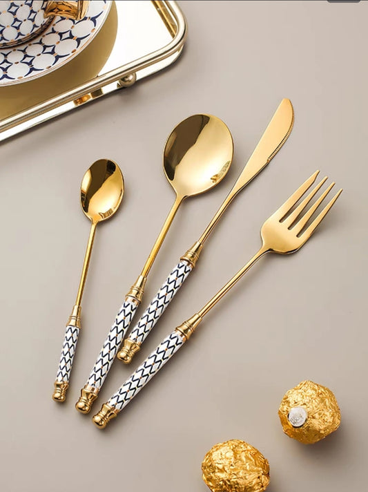 Elegant gold cutlery set with ceramic handles on luxury dining setup