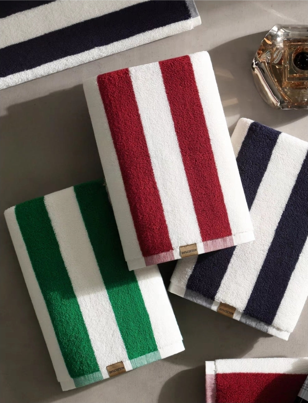 Green and White Striped Bath Towels Folded on Shelf