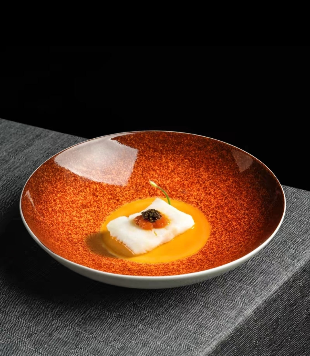 Glazed bone china dinner plate with artistic orange gradient finish, plated gourmet dish presentation
