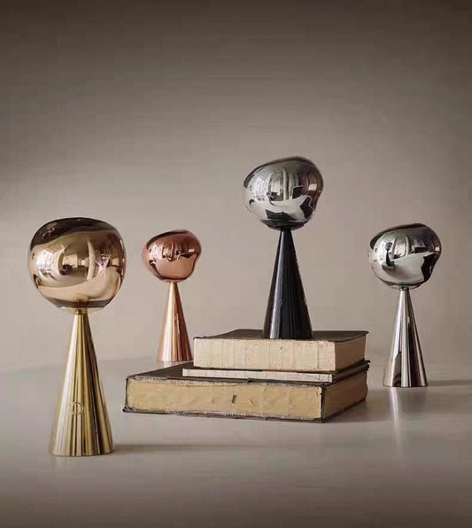 Molten glass LED table lamps with rechargeable cone bases in modern room setup.

