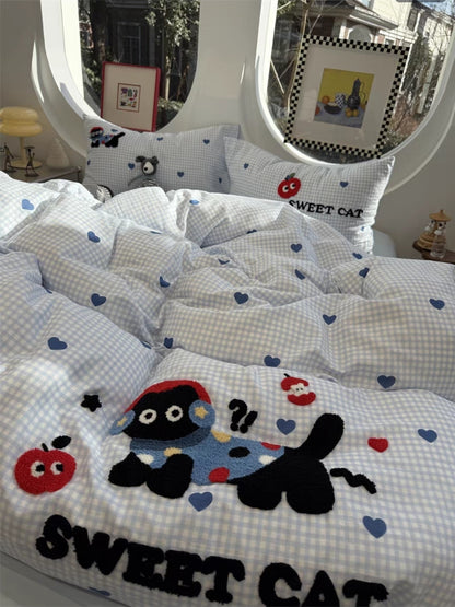 Children's bedding set with cartoon cat design and 'Sweet Cat' text on a checkered background.