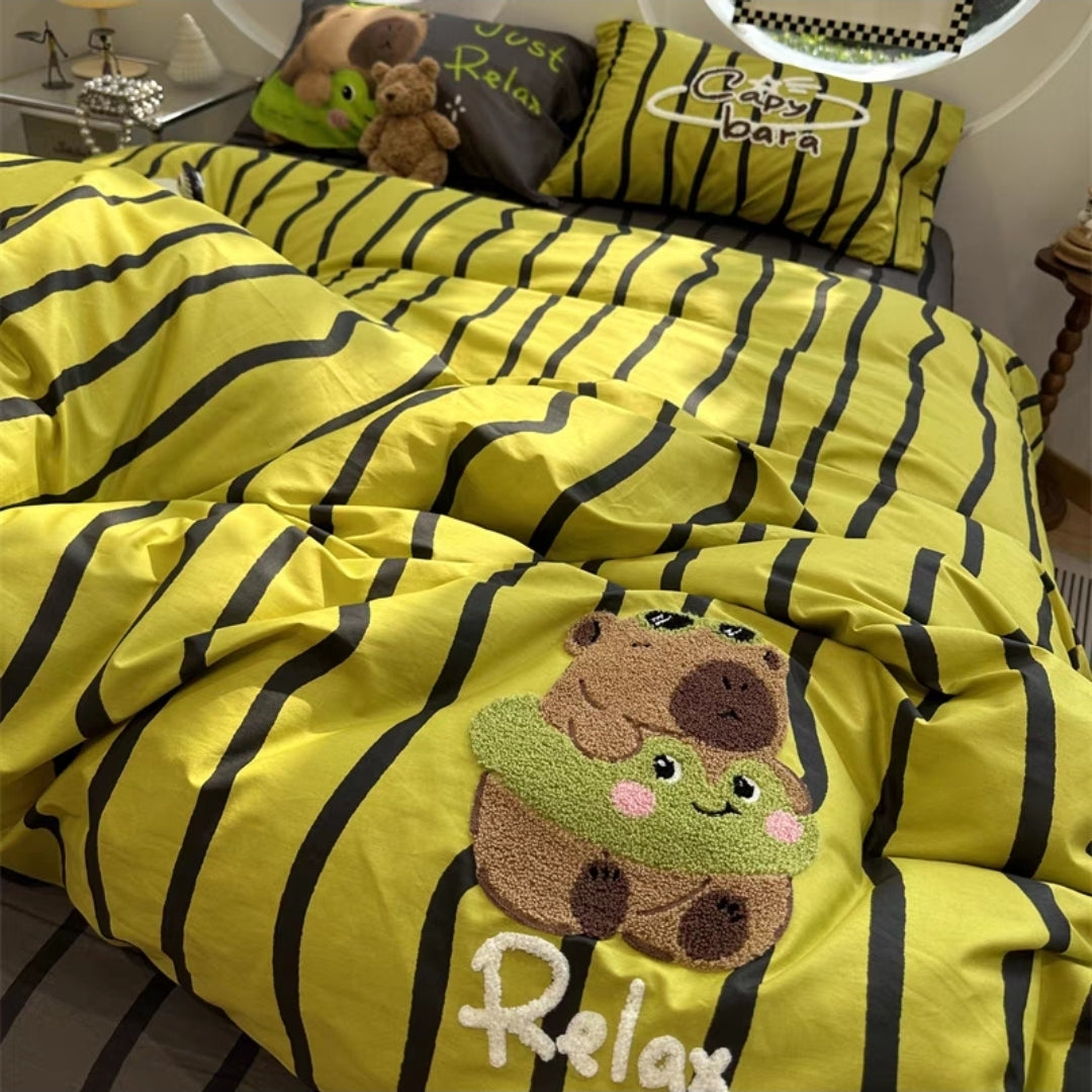 Yellow and black striped cartoon embroidered bedding set with a cartoon bear design on a bed.