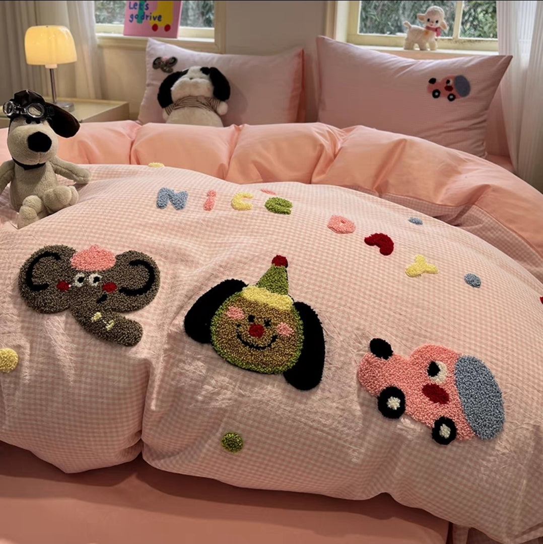 Children's bedroom with pink bedding featuring cartoon appliqués and plush toys.