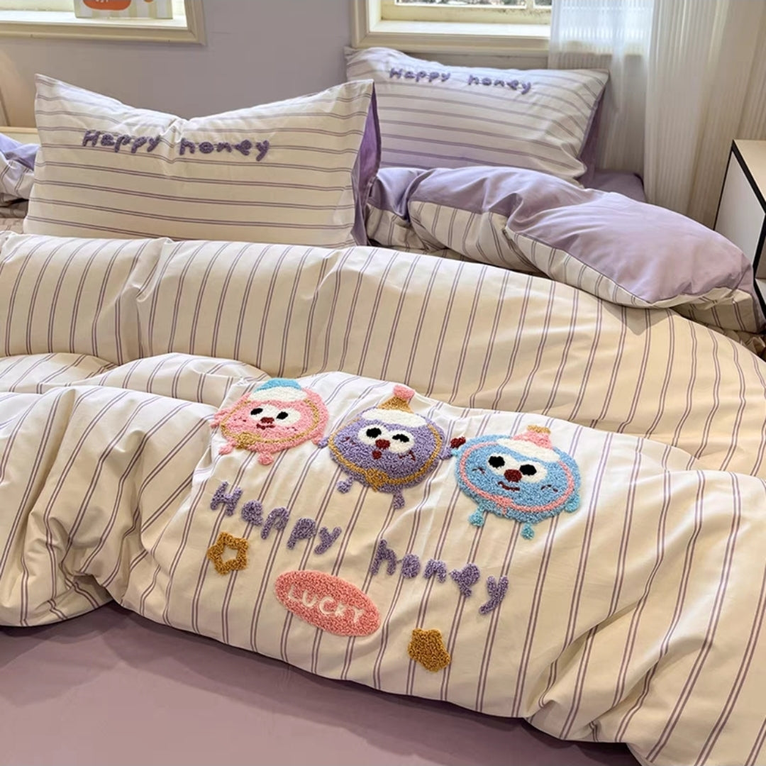 Striped bedding set with cartoon characters and text on a bed.