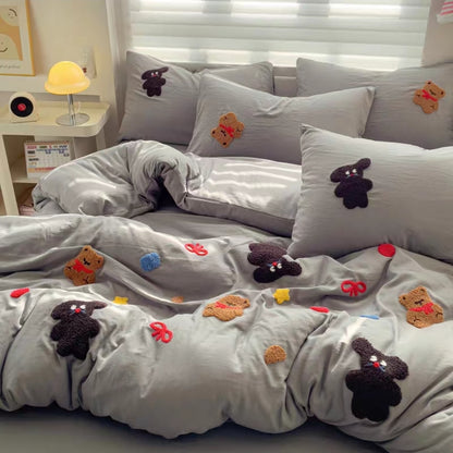 Gray cotton cartoon bedding set with embroidered animal faces on a bed in a bedroom setting.