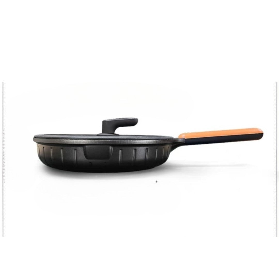 Black frying pan with an orange handle on a white background