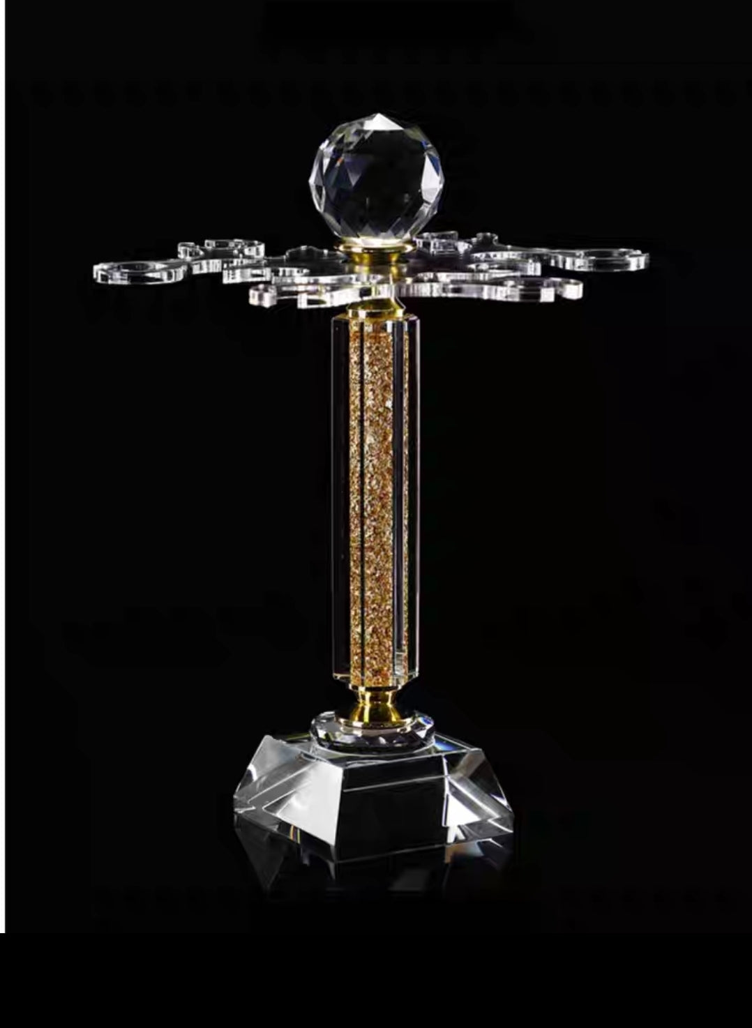 Crystal trophy with a central sphere and decorative elements on a black background