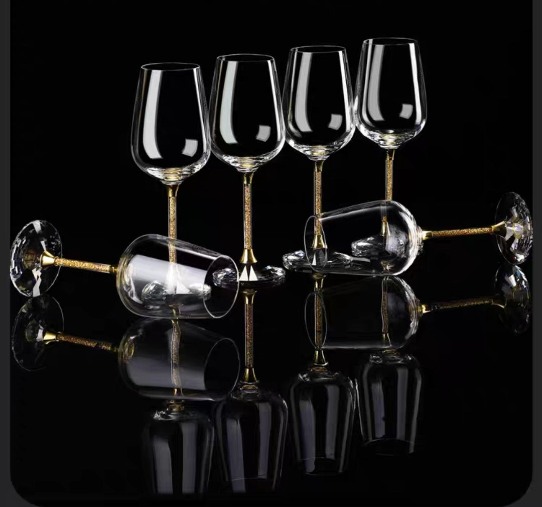 Hand-blown crystal wine glasses with gold foil detailing displayed with accessories