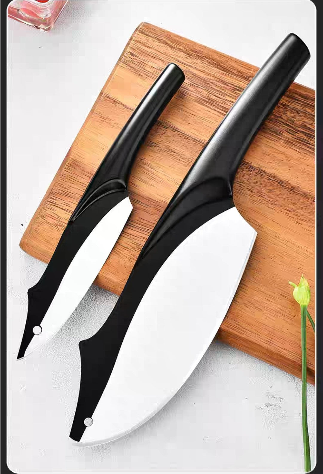 Minimalist black knife set arranged diagonally on a white surface

