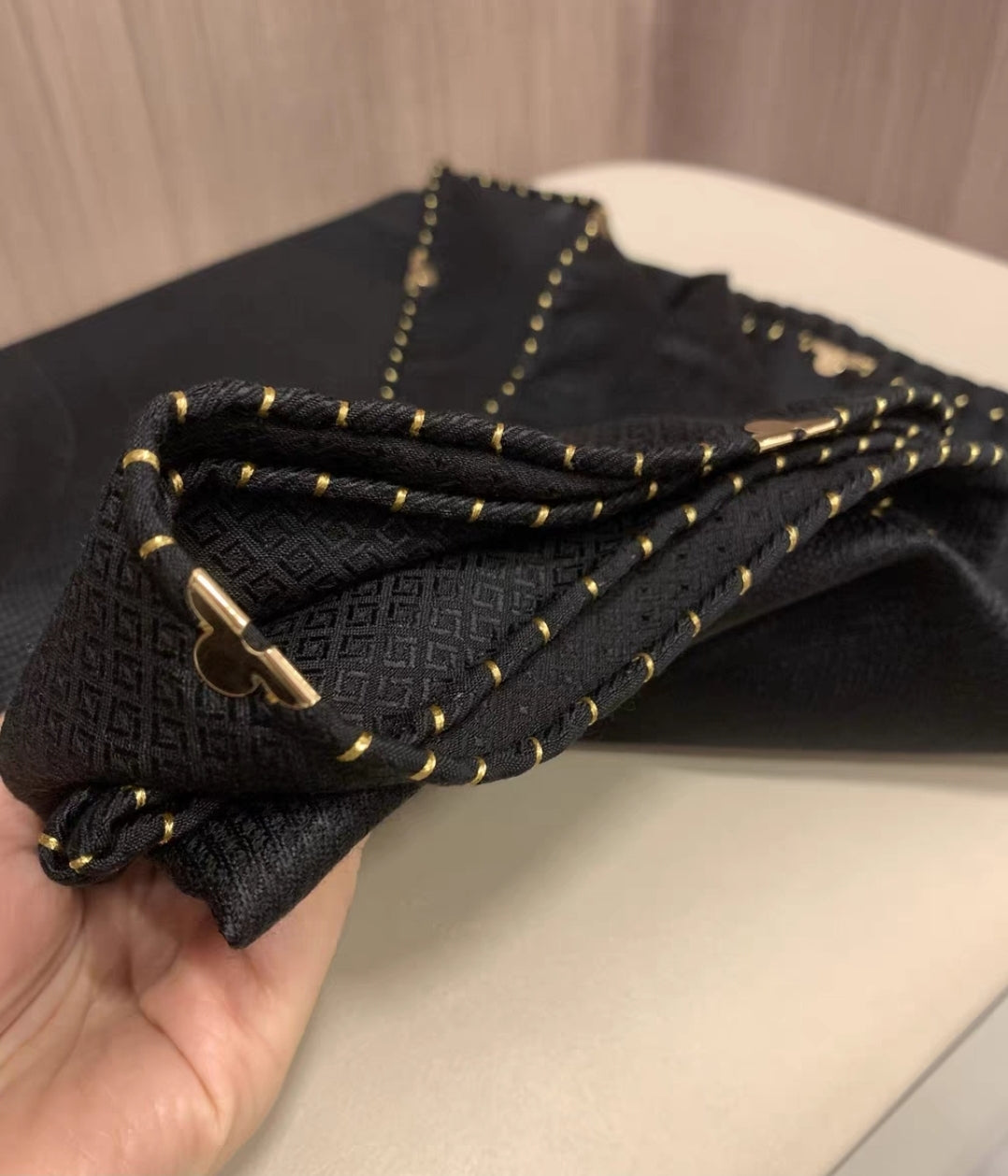 Golden detailed black shawl draped for stylish year-round wear
