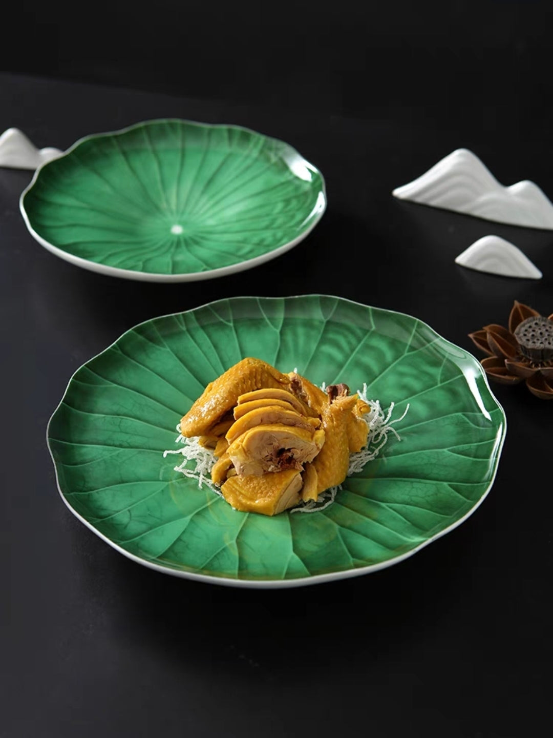 Sushi arranged on green lotus leaf ceramic plate, photo-worthy presentation
