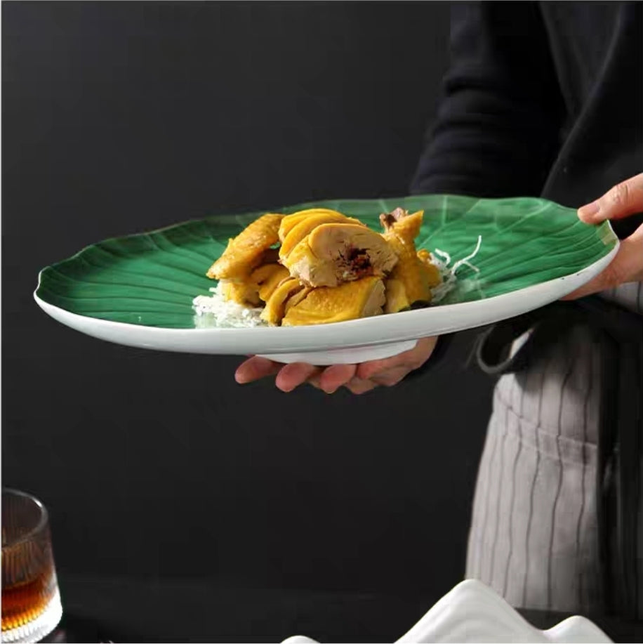 Variety of green lotus leaf plates in 20cm and 31cm sizes on wooden table.
