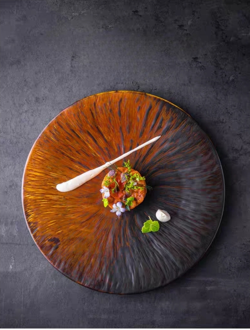 Kiln-glazed ceramic flat plate with irregular edge, matte finish, served with gourmet dish presentation
