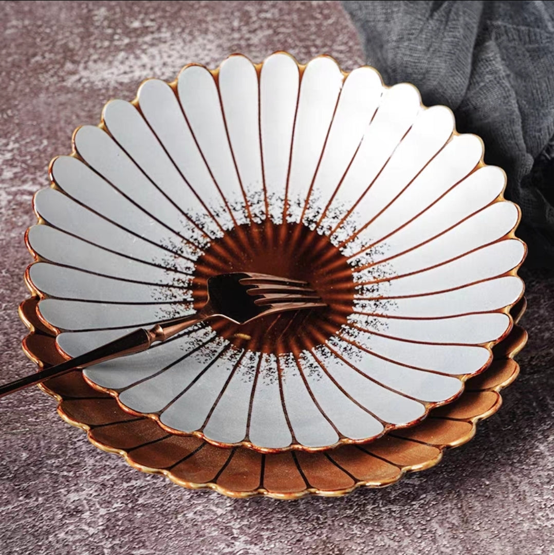 Decorative ceramic plate with gold and white design on a textured surface